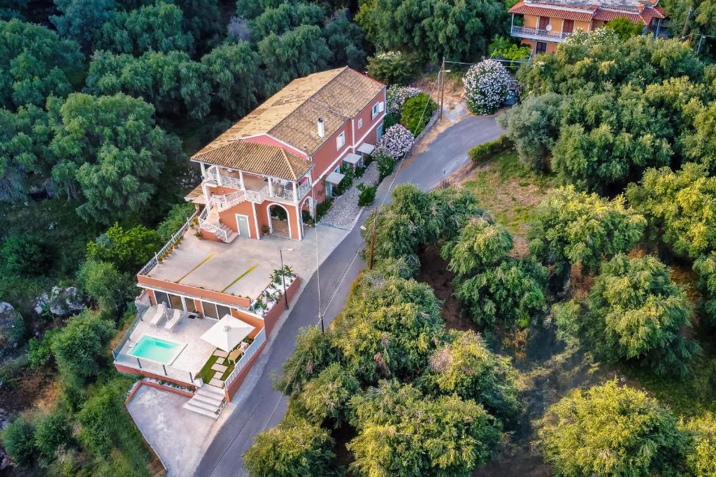 Aerial view of Stavroula Studios on its hillside above Paleokastritsa, surrounded by dense greenery